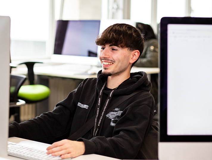 Student working at a desk in the media suite