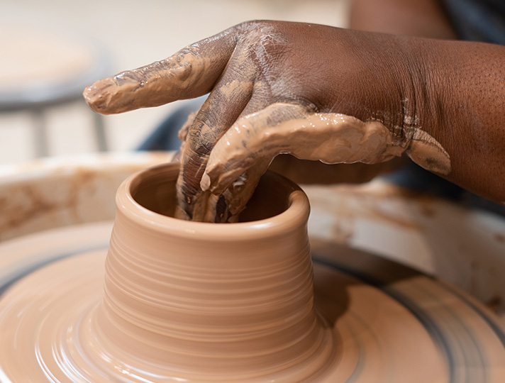 Hands hand building a pot in the studio